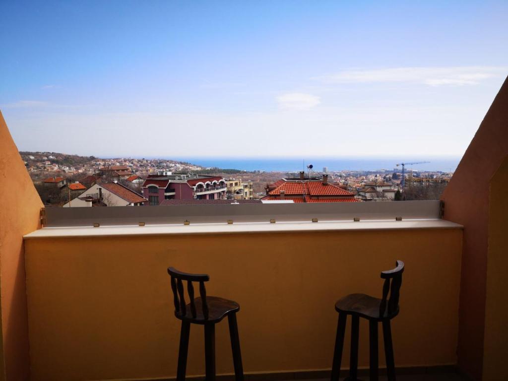 two chairs sitting at a bar with a view at Alfa Guest House - Free Parking in Varna City