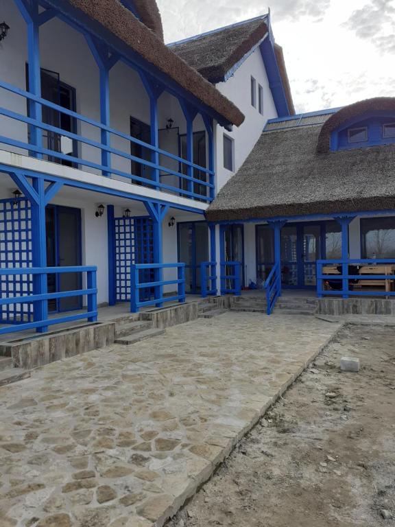 a blue and white building with a patio at Pensiunea Stuf-Est in Sfântu Gheorghe