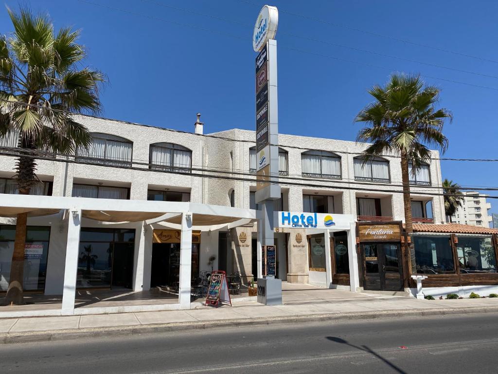 un hotel en una calle con palmeras delante en Hotel Canto del Mar en La Serena