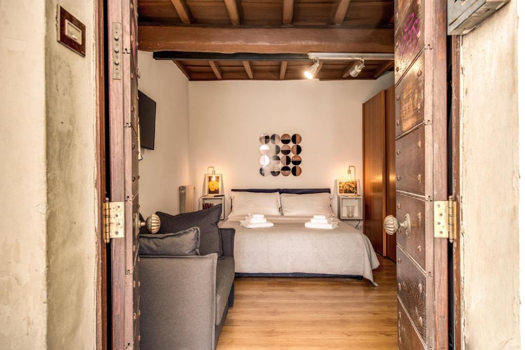 een slaapkamer met een bed en een bank bij 4C Colosseo Holidays in Rome