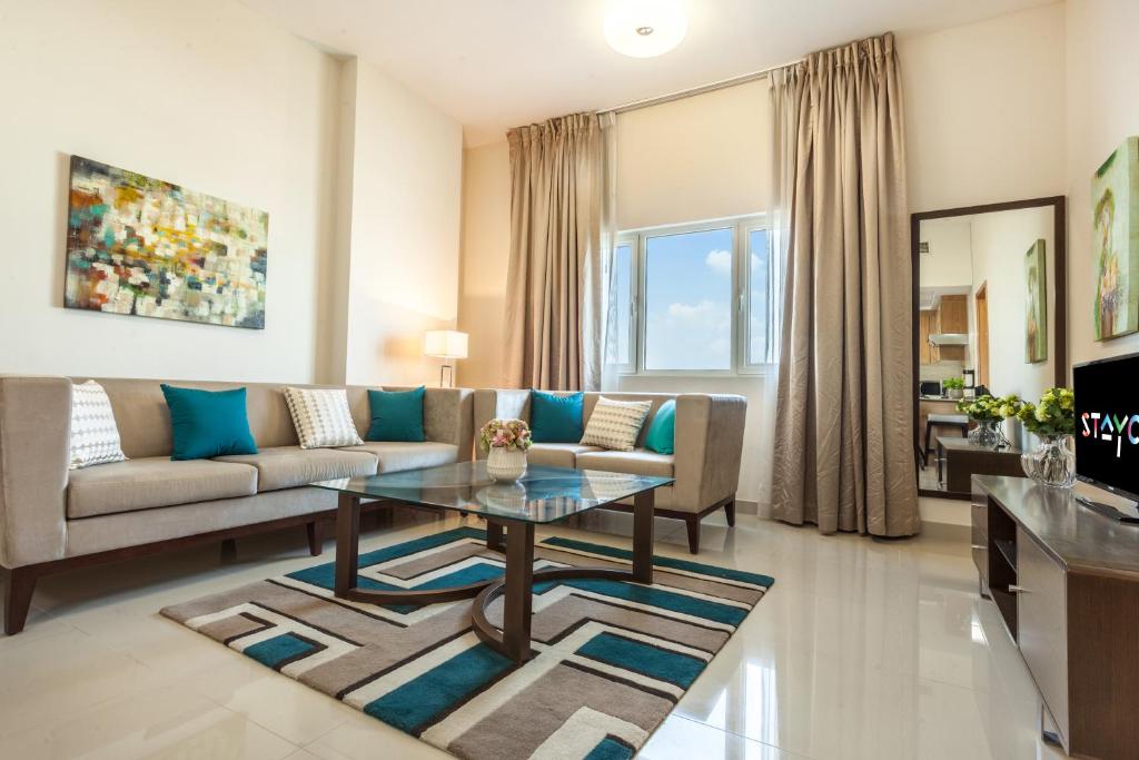 a living room with a couch and a table at Staycae Holiday Homes - Suburbia, Jebel Ali in Dubai