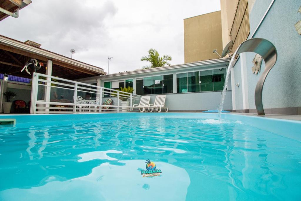 a swimming pool with a water fountain at Pousada Praia Brava in Matinhos