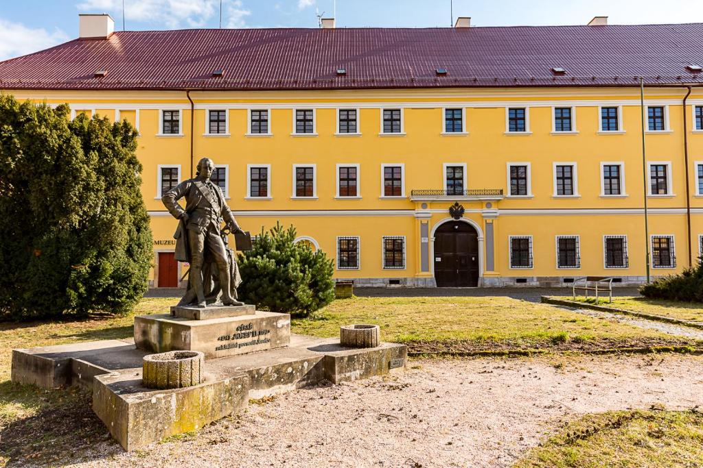 a statue in front of a yellow building at Ubytování 8 in Jaroměř