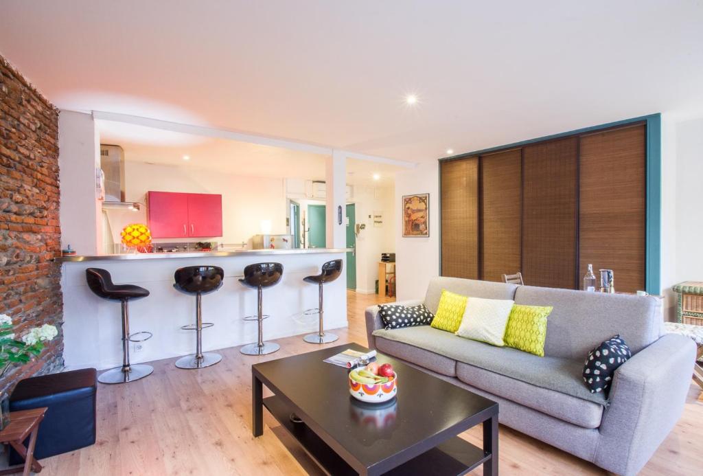 un salon avec un canapé et une cuisine dans l'établissement Rosa Bonheur by Cocoonr, à Toulouse