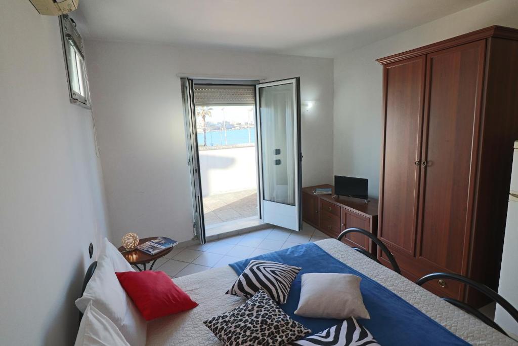 - une chambre avec un lit et une porte coulissante en verre dans l'établissement Casa vacanze frida a Otranto centro, Salento, mono 2/3 posti, à Otrante