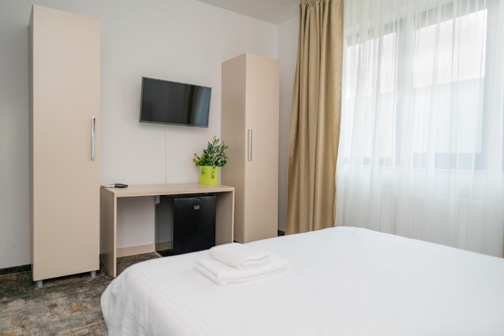 a hotel room with a bed and a television at FOREST M,Constanta in Valu lui Traian