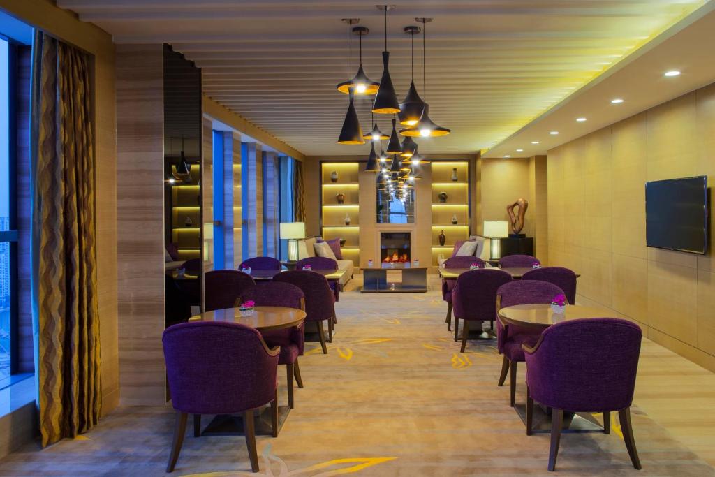une salle à manger avec des tables et des chaises violettes dans l'établissement Crowne Plaza Tianjin Meijiangnan, an IHG Hotel, à Tianjin
