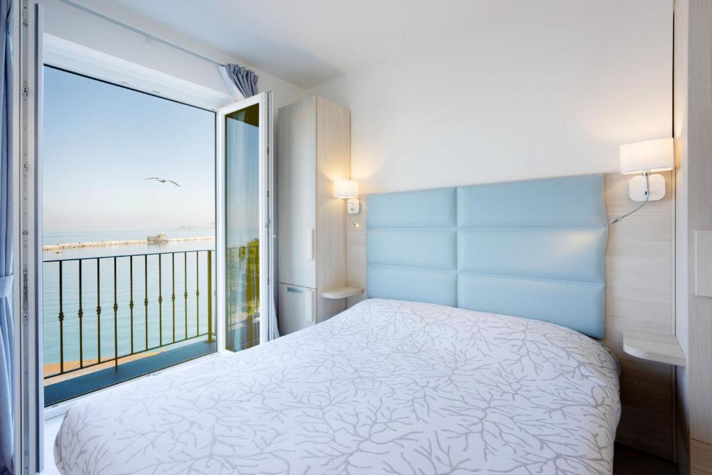 1 dormitorio con cama y ventana grande en Vento di mare en Procida