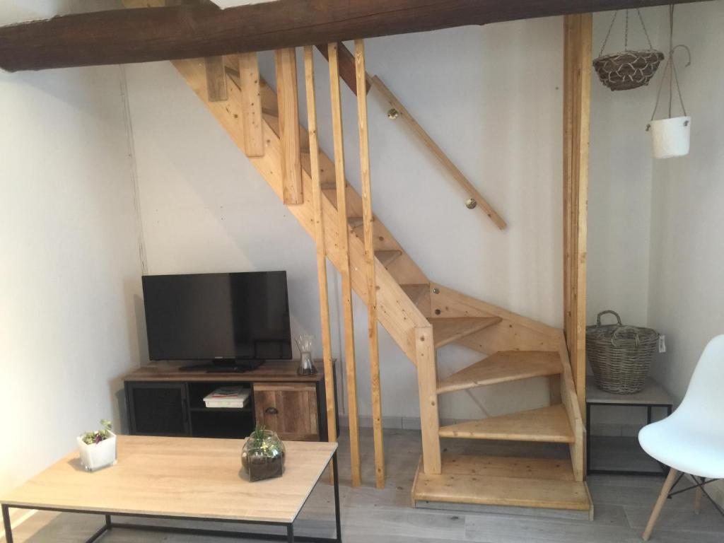 - un escalier en bois dans le salon doté d'une télévision dans l'établissement Maison de village - Monteux centre - Provence, à Monteux