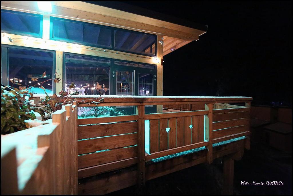 a wooden fence in front of a restaurant at night at Domaine du Hirtz, Restaurant &amp; Spa in Wattwiller