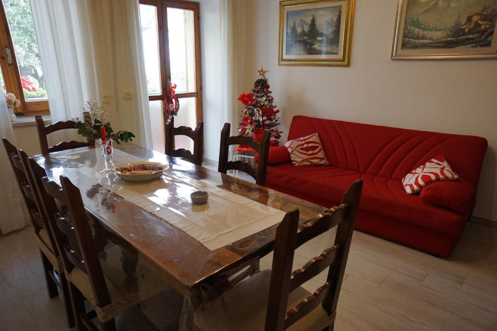salon ze stołem i czerwoną kanapą w obiekcie B&b In Piazza - San Gemini - Umbria w mieście San Gemini