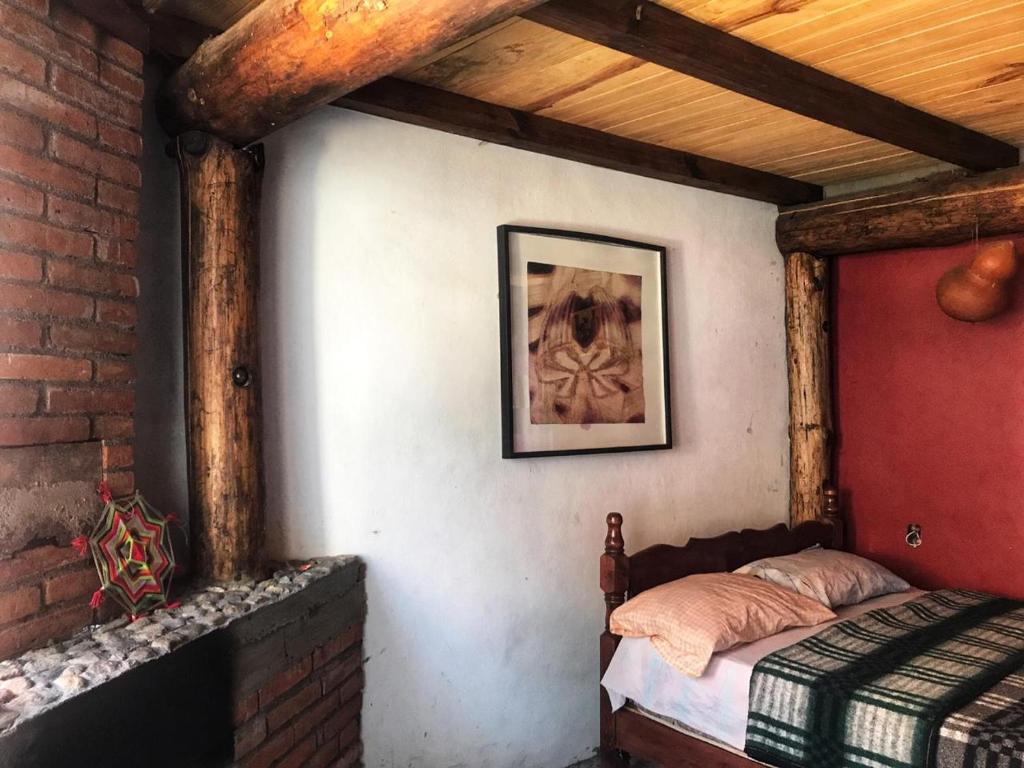 ein Schlafzimmer mit einem Bett und einer Ziegelwand in der Unterkunft Hostal mandala Evelyn in El Pacífico
