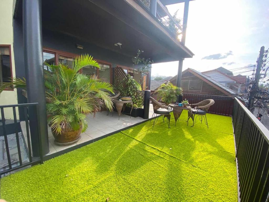un balcone con tappeto verde sul pavimento di Green​ house​ Samui a Bophut