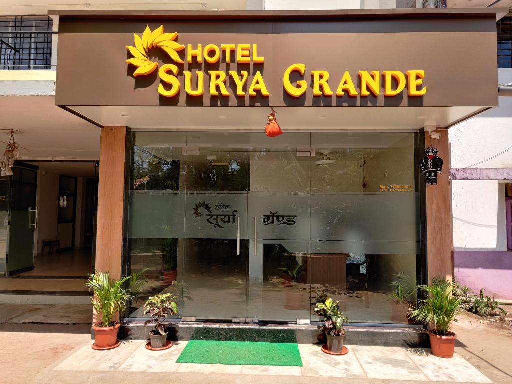 un hotel suriya nietade con plantas delante de él en Hotel Surya Grande, en Kudāl