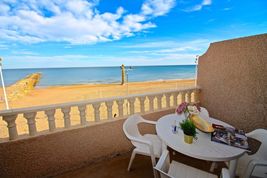 una mesa en un balcón con vistas a la playa en Apartamento Mistral Beach, en El Campello