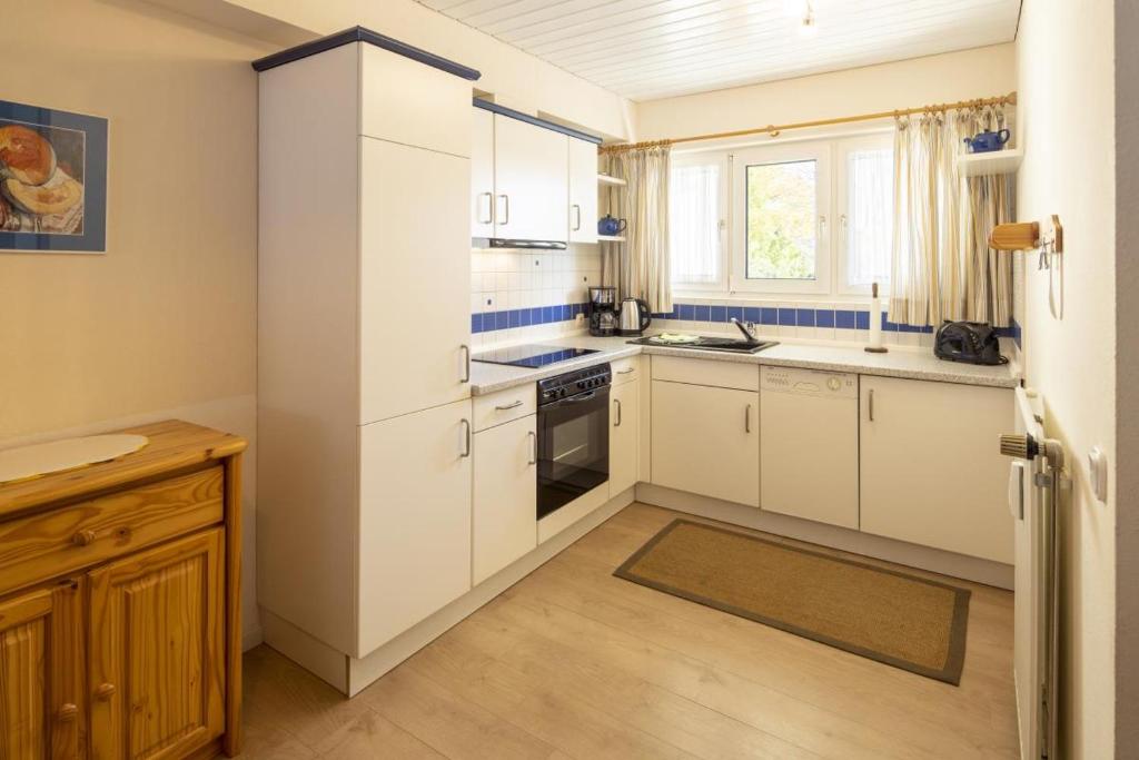 a kitchen with white cabinets and a stove top oven at Fewo am Edersee mit 2 Schlafzimmern in Scheid