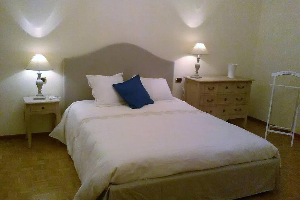 a bedroom with a large white bed with two lamps at Charming Family Lodge With Private Garage in Florence