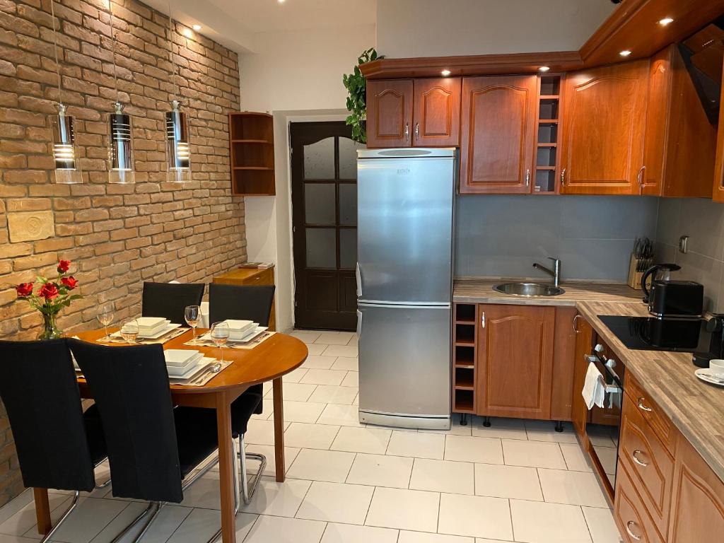 a kitchen with a table and a stainless steel refrigerator at Budapest Central Andrassy Apartment in Budapest