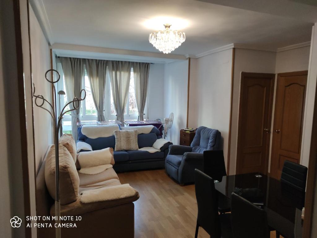 salon z niebieską kanapą i krzesłami w obiekcie Habitación JC w Madrycie