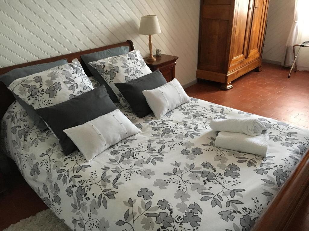 a bed with black and white sheets and pillows at les mésanges in Bourré