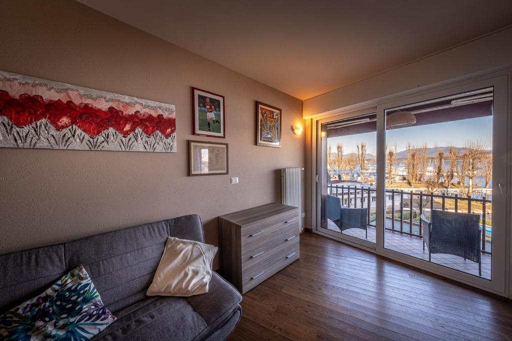 ein Wohnzimmer mit einem Sofa und einem Balkon in der Unterkunft La finestra sul Lago in Dormelletto
