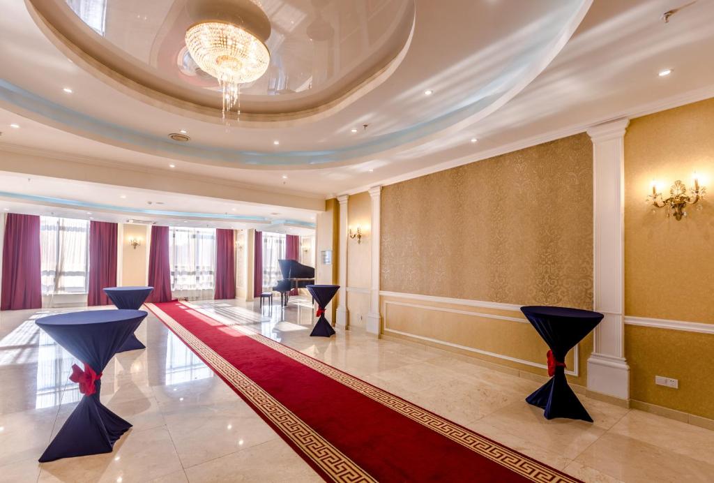a lobby with a red carpet and a chandelier at Holiday Inn Ulaanbaatar by IHG in Ulaanbaatar