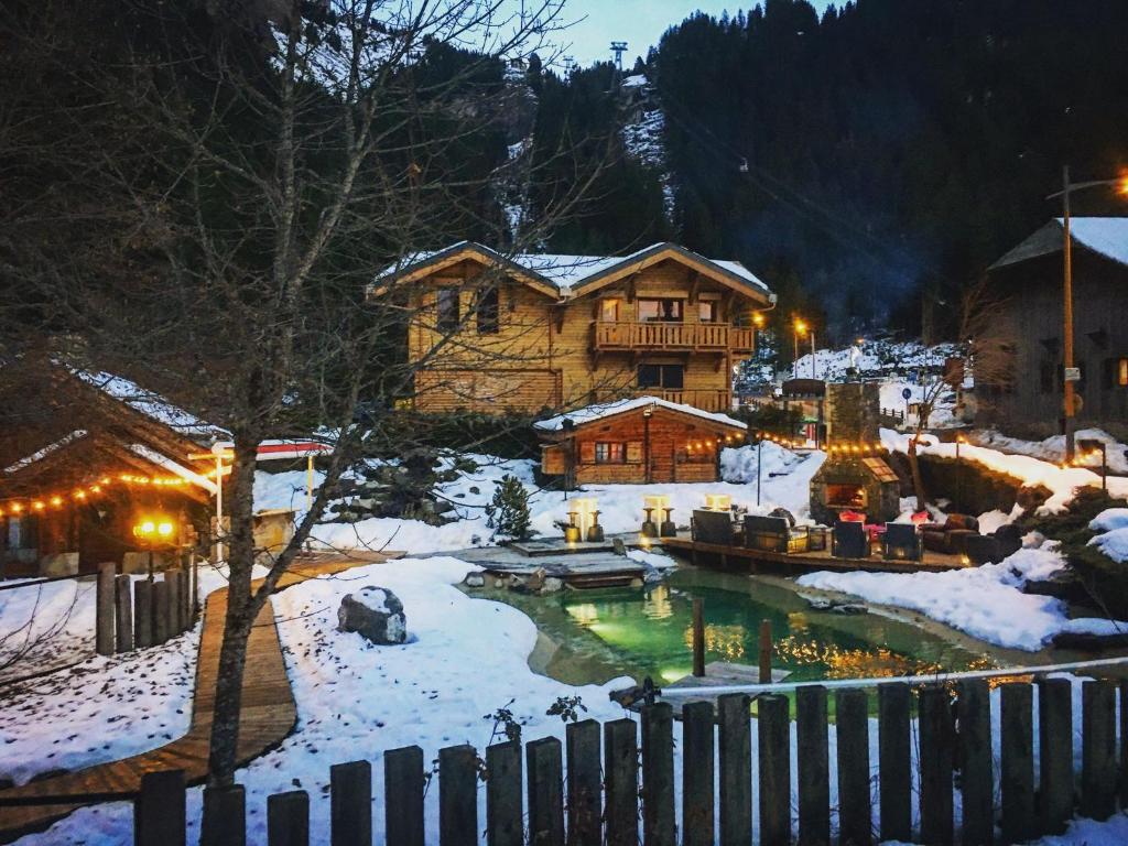 a house in the snow with a pond at Chalet Croq'Neige in Morzine