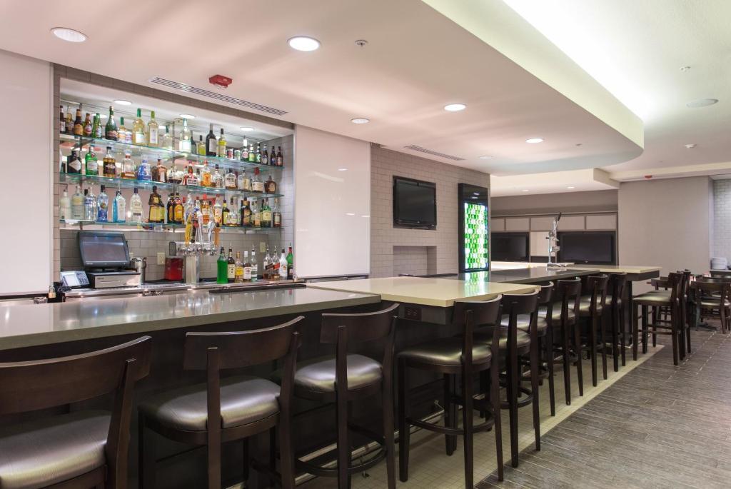 a bar with a bunch of stools in a restaurant at Holiday Inn Texarkana Arkansas Convention Center by IHG in Texarkana