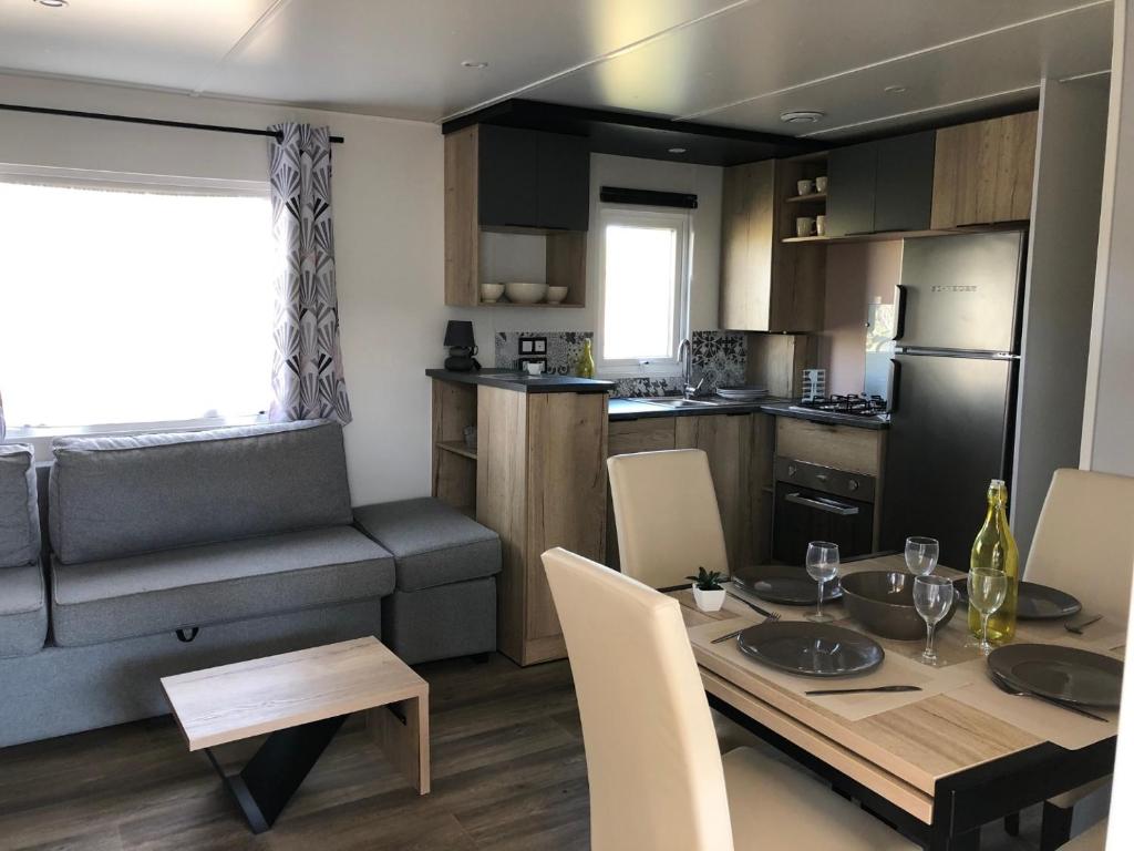 a kitchen and dining room with a table and chairs at camping les sables du midi in Valras-Plage