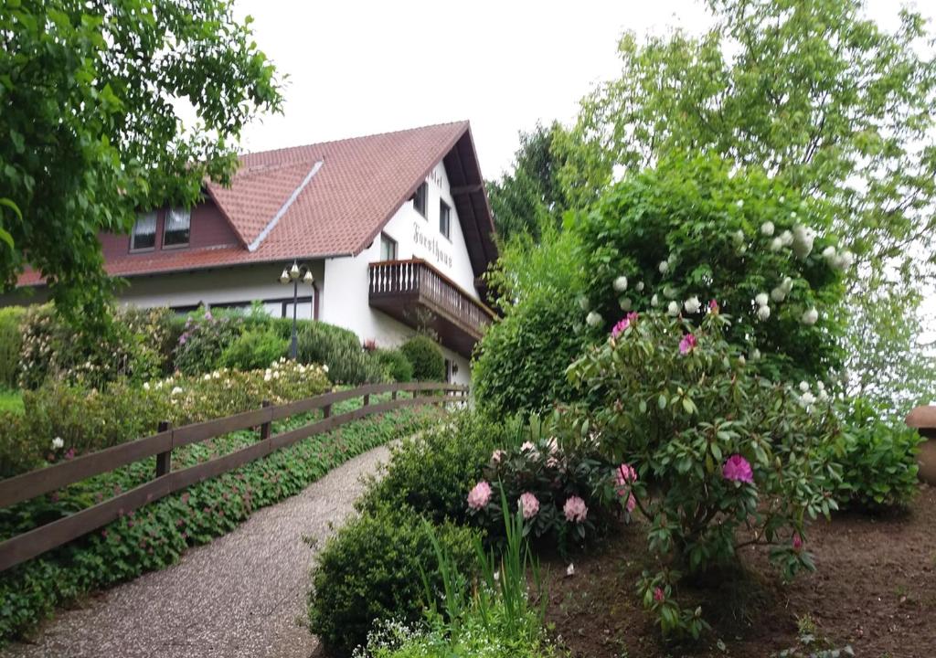 Forsthaus Alter Foerster في باد اوينهاوسن: حديقة امام بيت به ورد