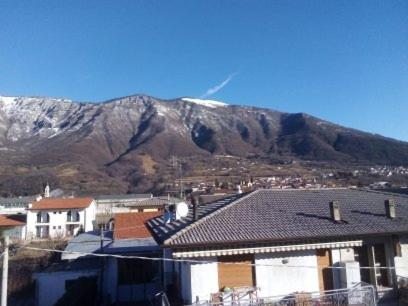 a mountain in the background of a town with houses at affitacamere zimmer nadia in Chiuppano