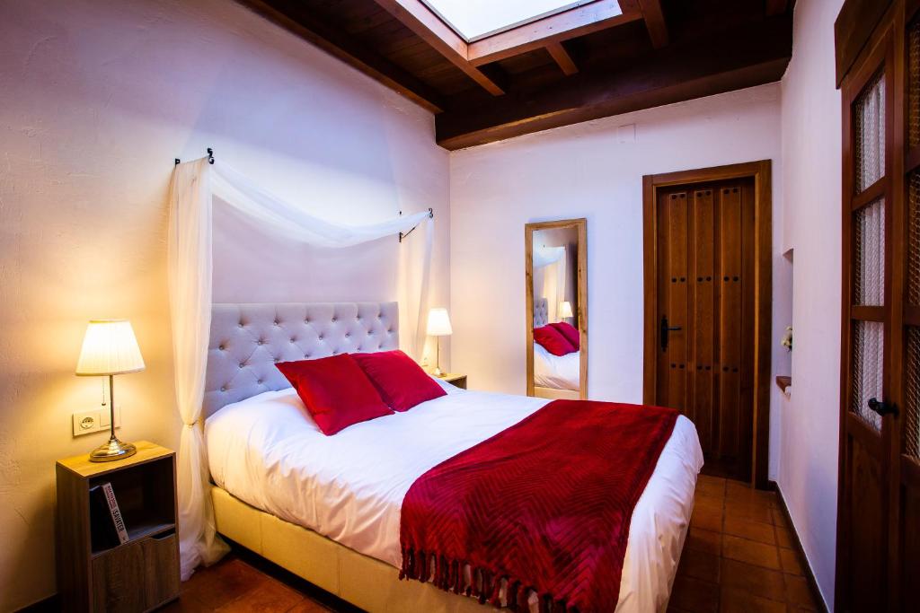 sypialnia z dużym łóżkiem i czerwonym kocem w obiekcie Apartamentos Puente de la Judería w mieście Hervás