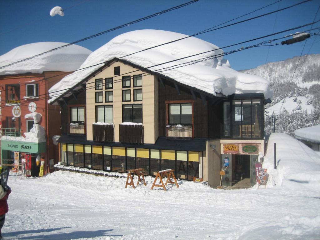 un edificio en una pista de esquí con nieve. en Lodge Nakajima, en Nozawa Onsen