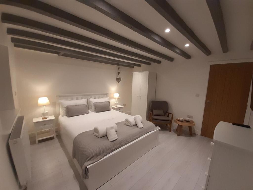 um quarto com uma cama grande e toalhas em Cottage Apartment by Seaside Llandudno em Llandudno