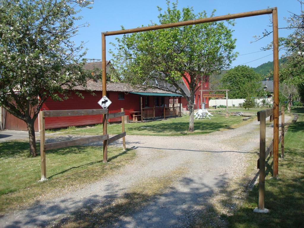Czerwona stodoła z bramą i polną drogą w obiekcie Tiny House Westen Life w mieście Romilly-sur-Andelle