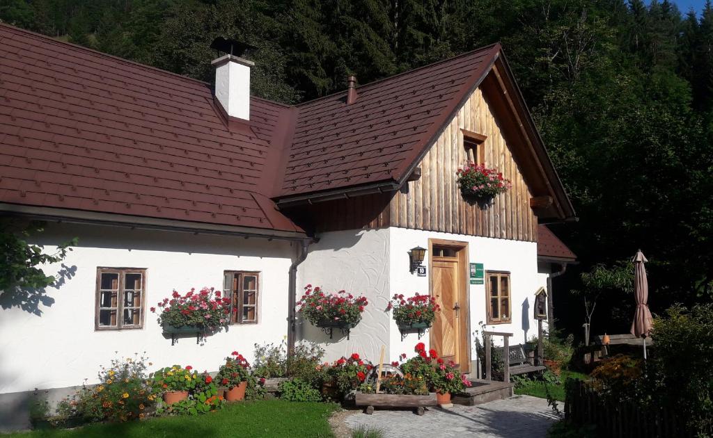 Biały dom z kwiatami przed nim w obiekcie Ferienhaus Lenzau w mieście Strohmarkt