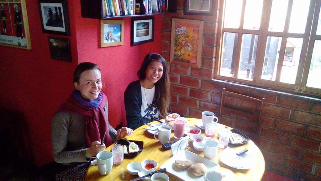 two people sitting at a table in a restaurant at Monkeywasi Climbing Hostel in Huaraz