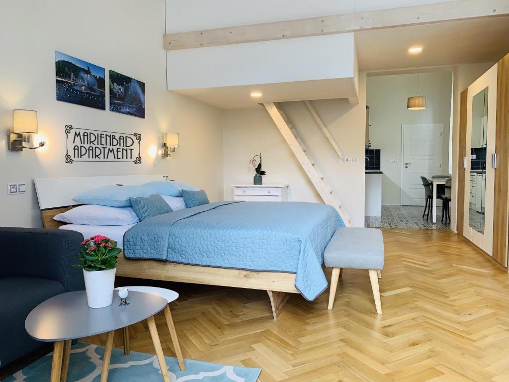 um quarto com uma cama azul e uma sala de estar em Marienbad Apartment em Mariánské Lázně