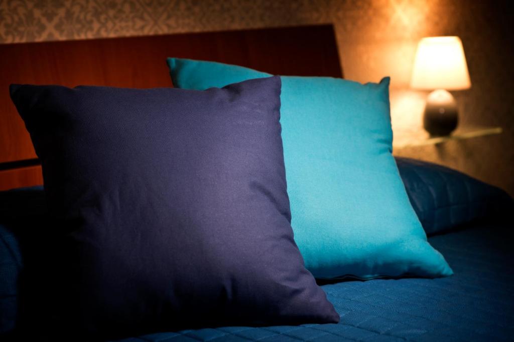un cuscino blu seduto su un letto accanto a una lampada di Civale Holidays Apartment a Vietri