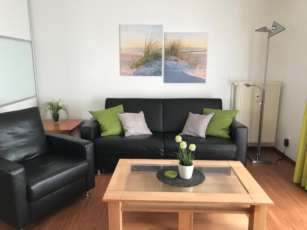 a living room with a couch and a coffee table at Steiner Strandappartements Appartement 210 Südseite mit seitlichem Meerblick in Stein