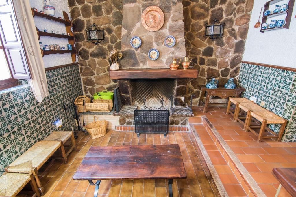 Una chimenea en una habitación con una pared de piedra. en tuGuest Country House Monachil, en Granada