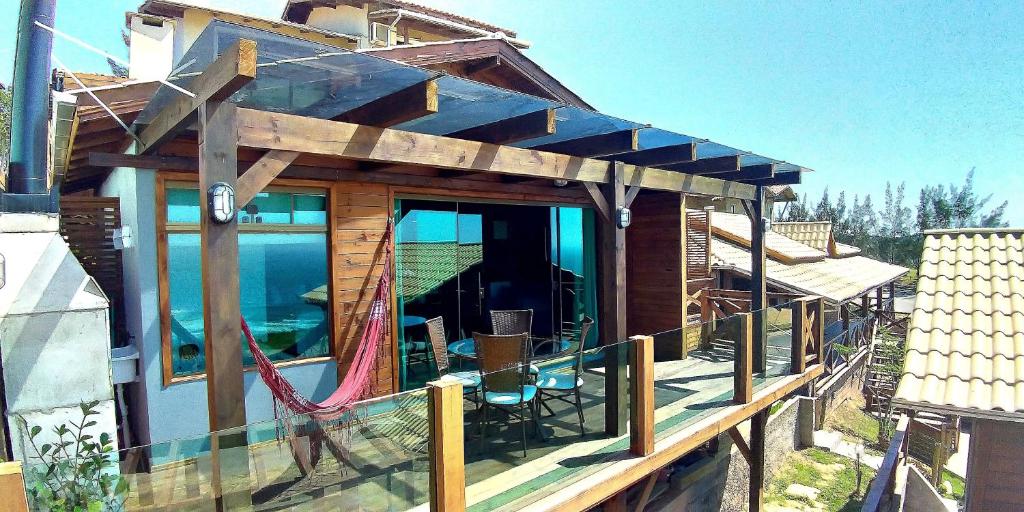 a house with a deck with a hammock on it at Chalés Mirante da Zimba in Imbituba