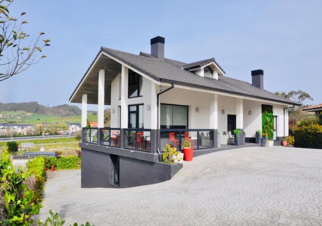 a house with a large driveway in front of it at Coccoa Boutique Hotel in Boó de Piélagos