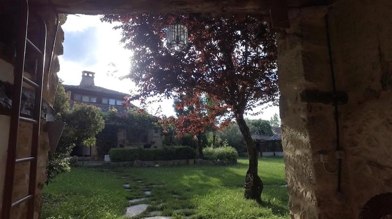 a view of a yard with a tree and a house at casa rural decerca in Arcones