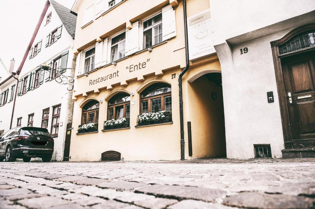 ein Gebäude auf einer Straße mit einem Auto vor der Tür in der Unterkunft Restaurant Residence Ente in Biberach an der Riß