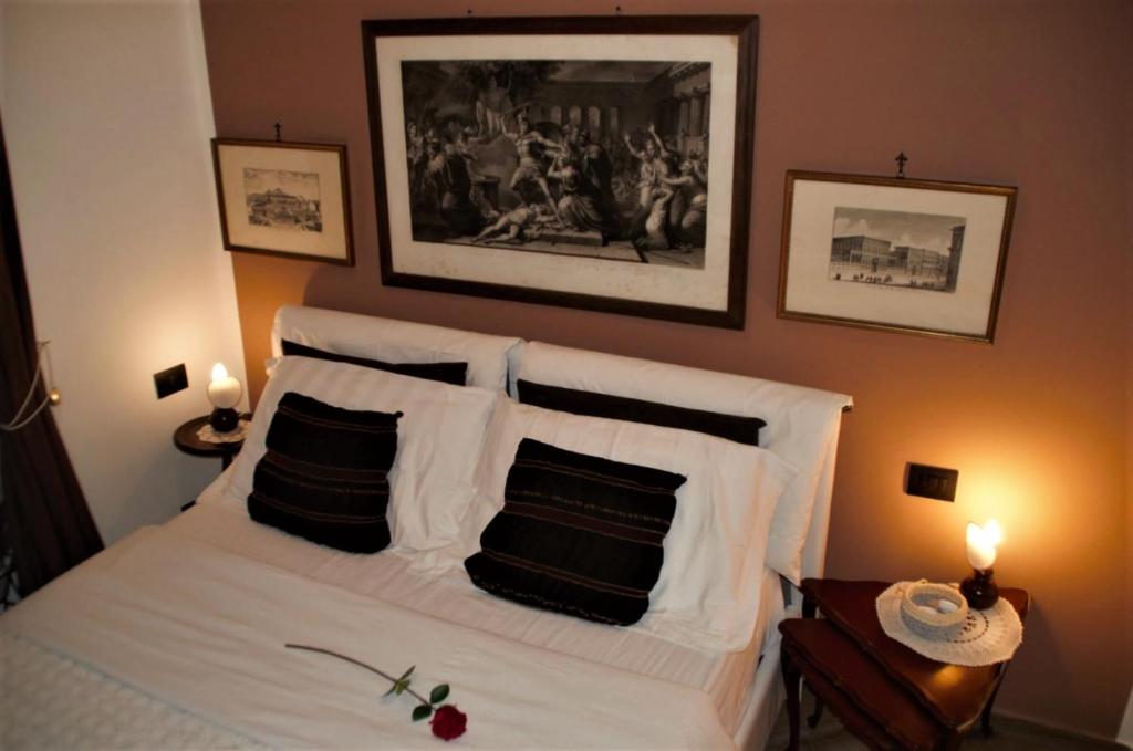 a bedroom with a white bed with black and white pillows at Ipazia House in Genoa