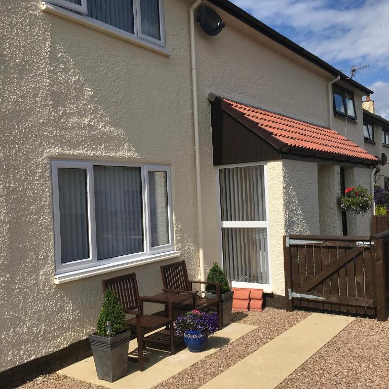 a house with two chairs and a balcony at Highland Escape in Fort William