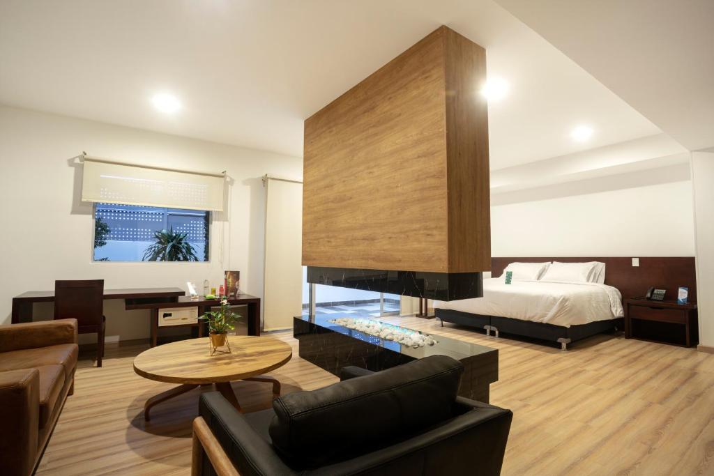 uma sala de estar com uma cama e uma lareira em Loft Hotel Ipiales em Ipiales