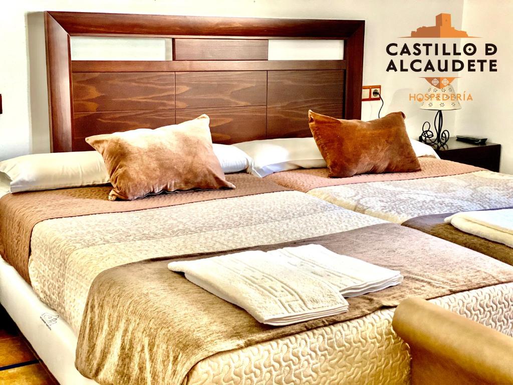 dos camas sentadas una al lado de la otra en una habitación en HOSPEDERÍA CASTILLO DE ALCAUDETE, en Alcaudete