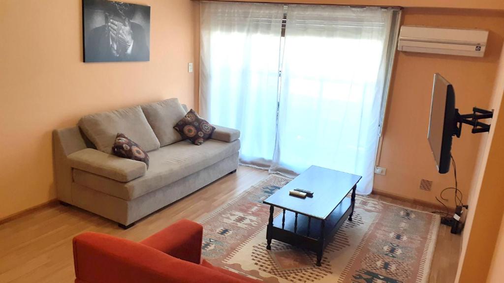 a living room with a couch and a table at Danny ap - Amplio y cómodo - 18 min Aeropuerto - Zona de Restos - Parking in Monte Grande